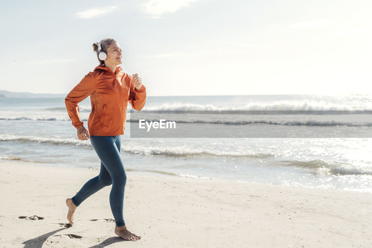 Woman jogging on shore at beach