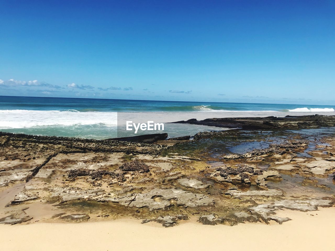 Scenic view of beach against blue sky