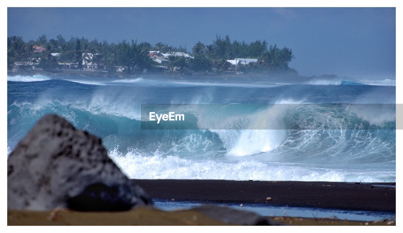 SCENIC VIEW OF WAVES BREAKING AGAINST CLEAR SKY