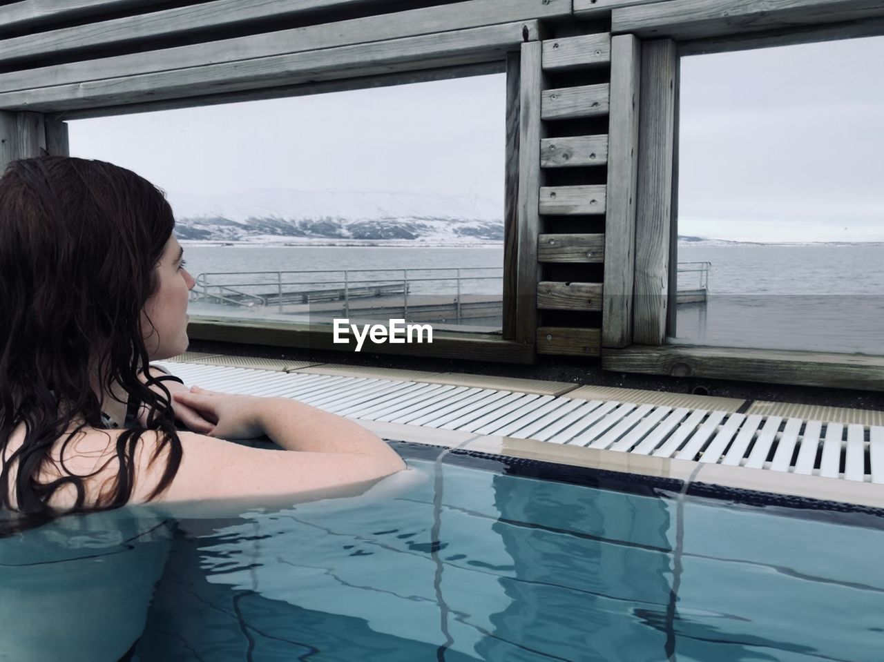 A woman enjoying the view in icelandic natural spring pool, in laugarvatn fontana, iceland