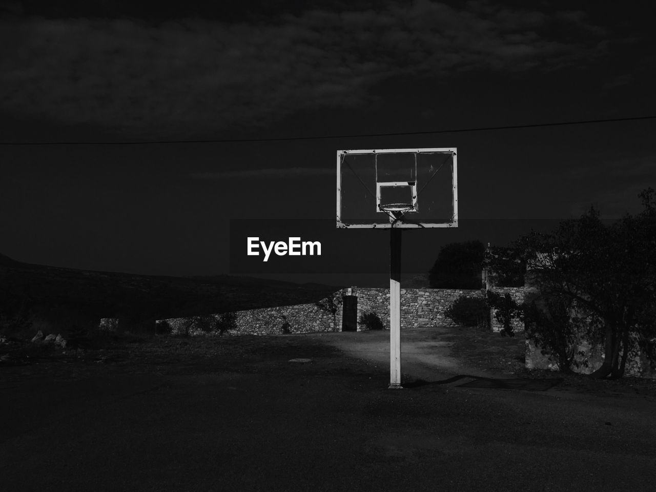 Basketball hoop against sky at night