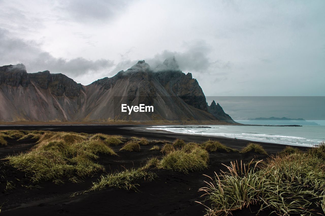 Scenic view of sea and mountains against sky