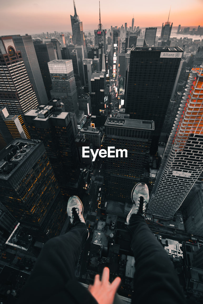 LOW ANGLE VIEW OF MAN AND CITYSCAPE