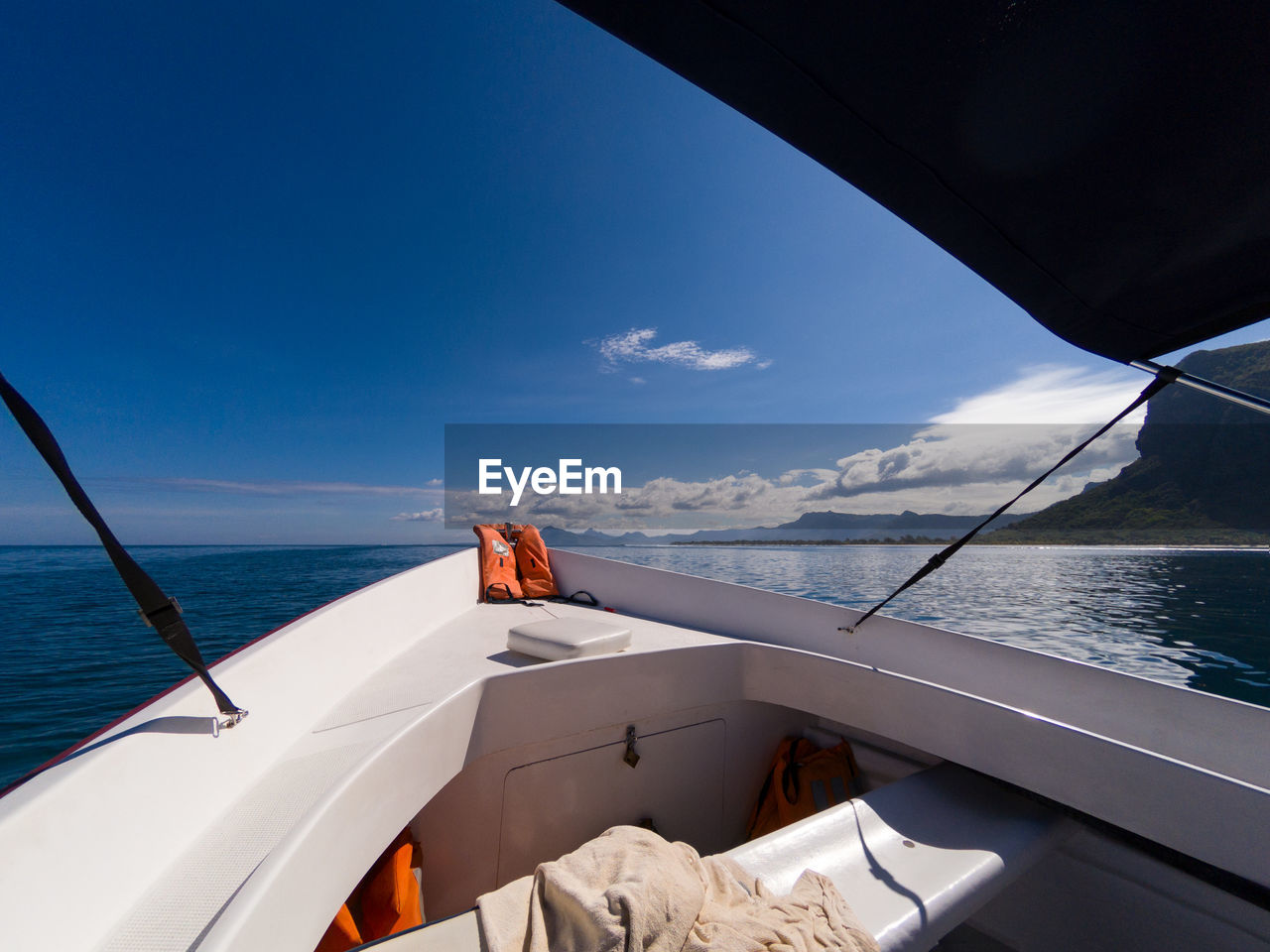 BOAT SAILING IN SEA AGAINST SKY