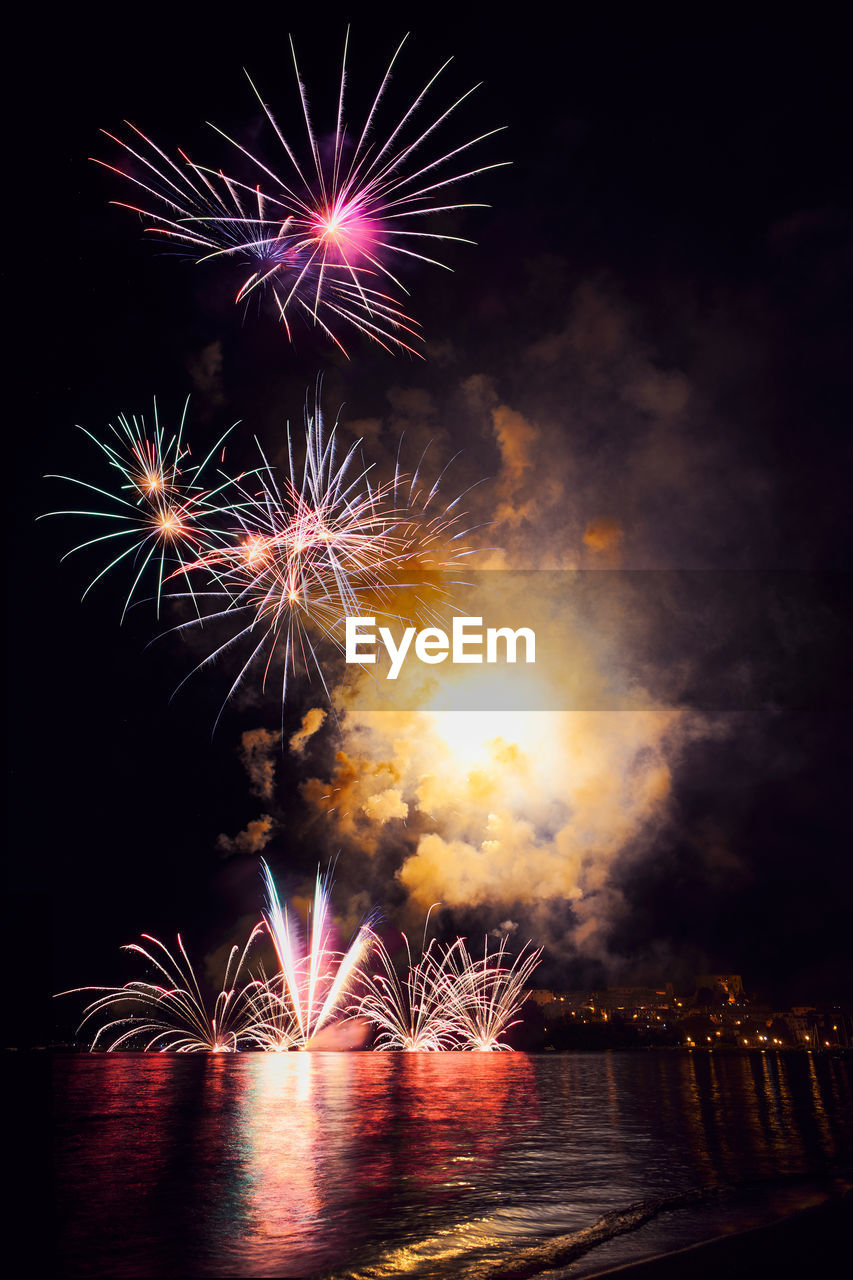 Landscape of the town of capodimonte on bolsena lake during firework on the beach