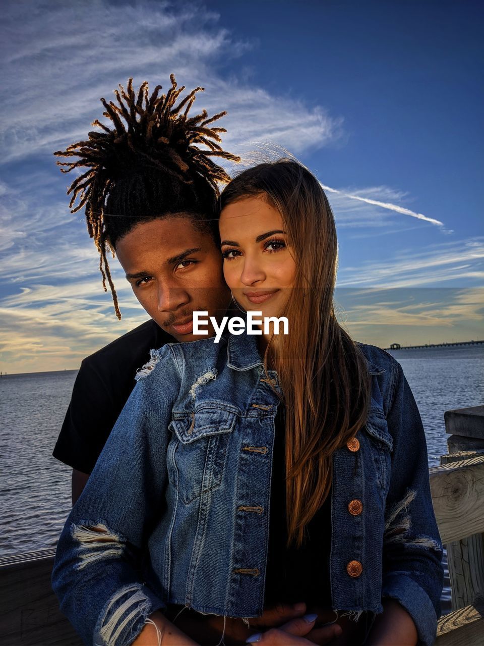 Portrait of young couple against sea and sky