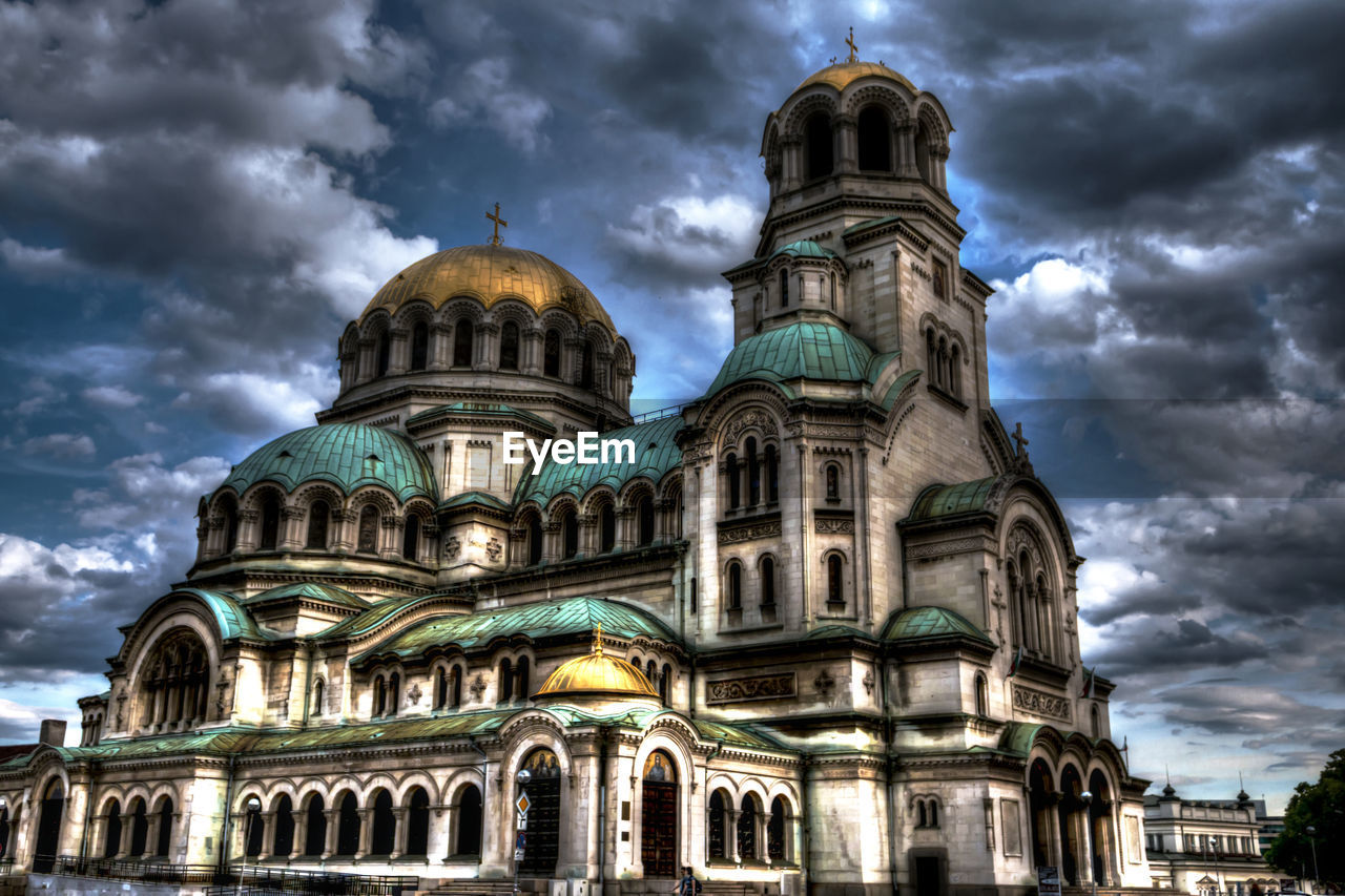 EXTERIOR OF CATHEDRAL AGAINST CLOUDY SKY