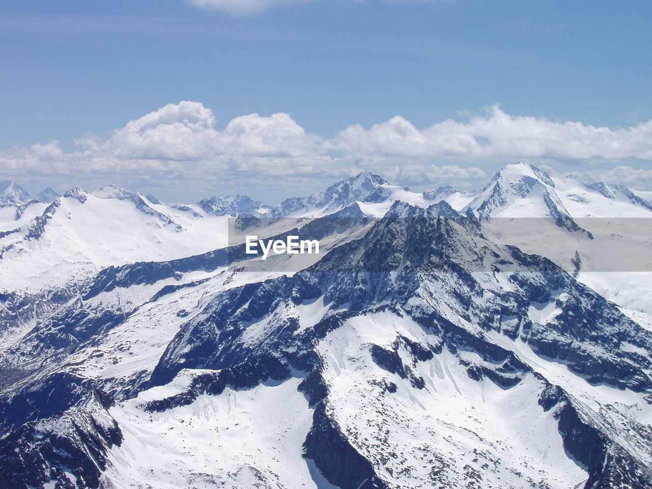 AERIAL VIEW OF SNOWCAPPED MOUNTAINS AGAINST SKY