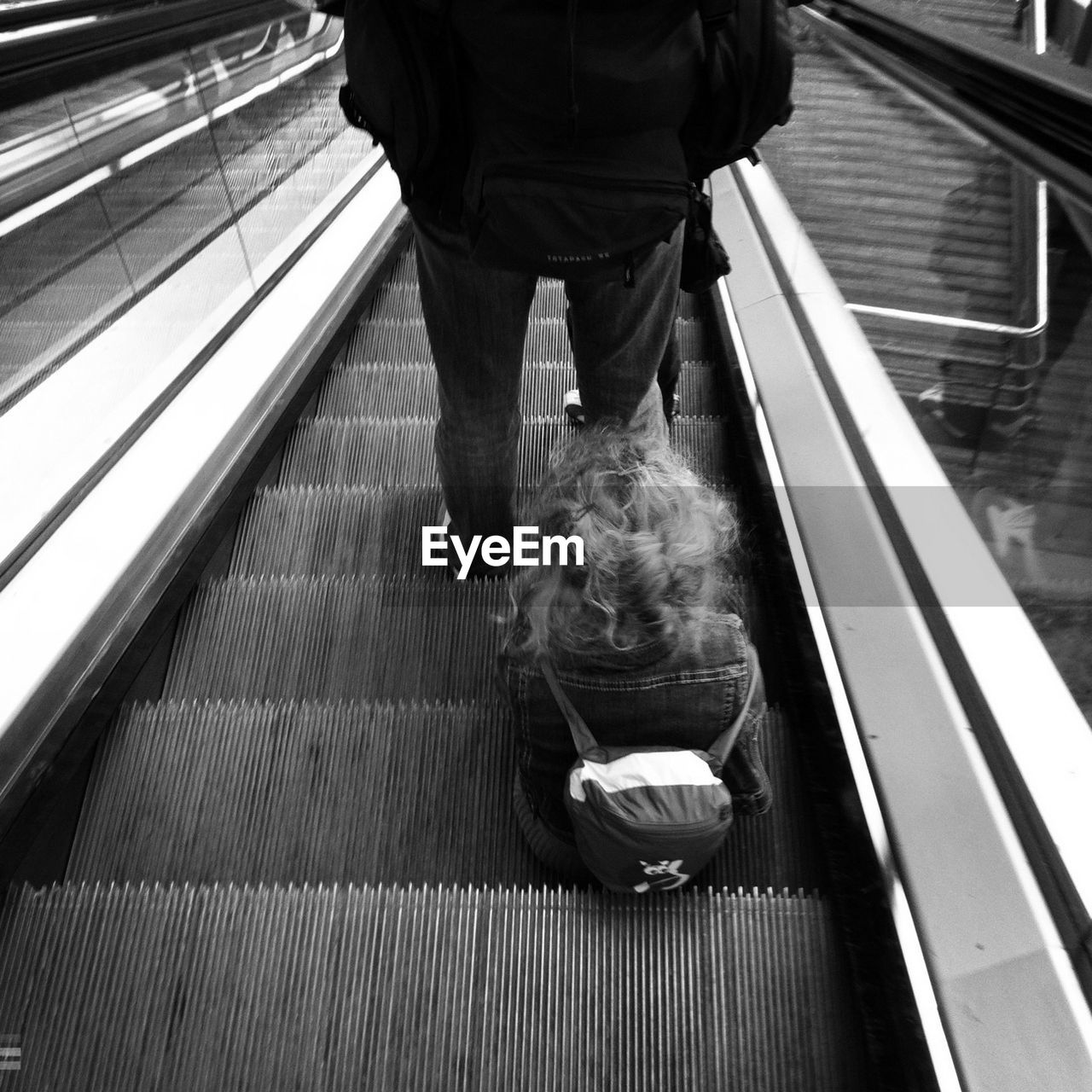 Rear view of a girl sitting on escalator