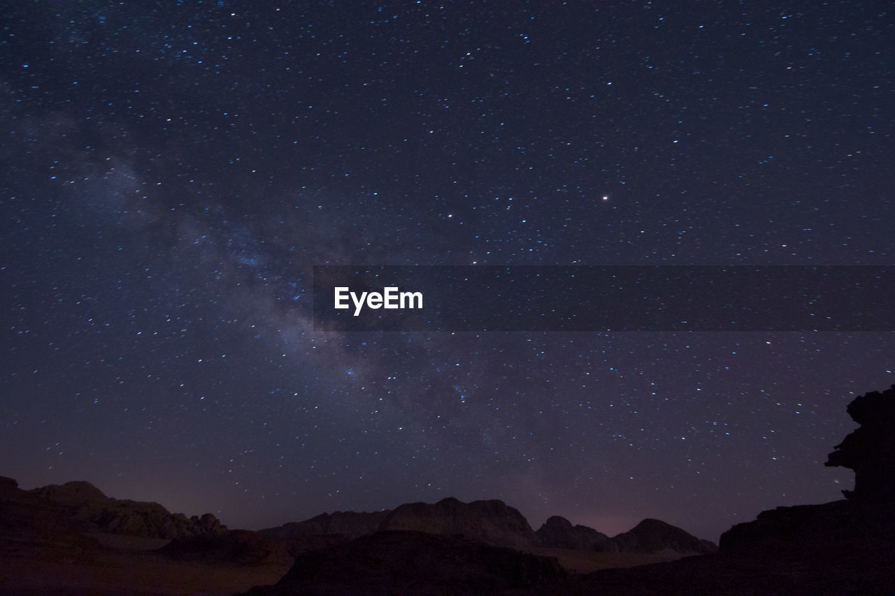 Low angle view of silhouette mountain against sky at night