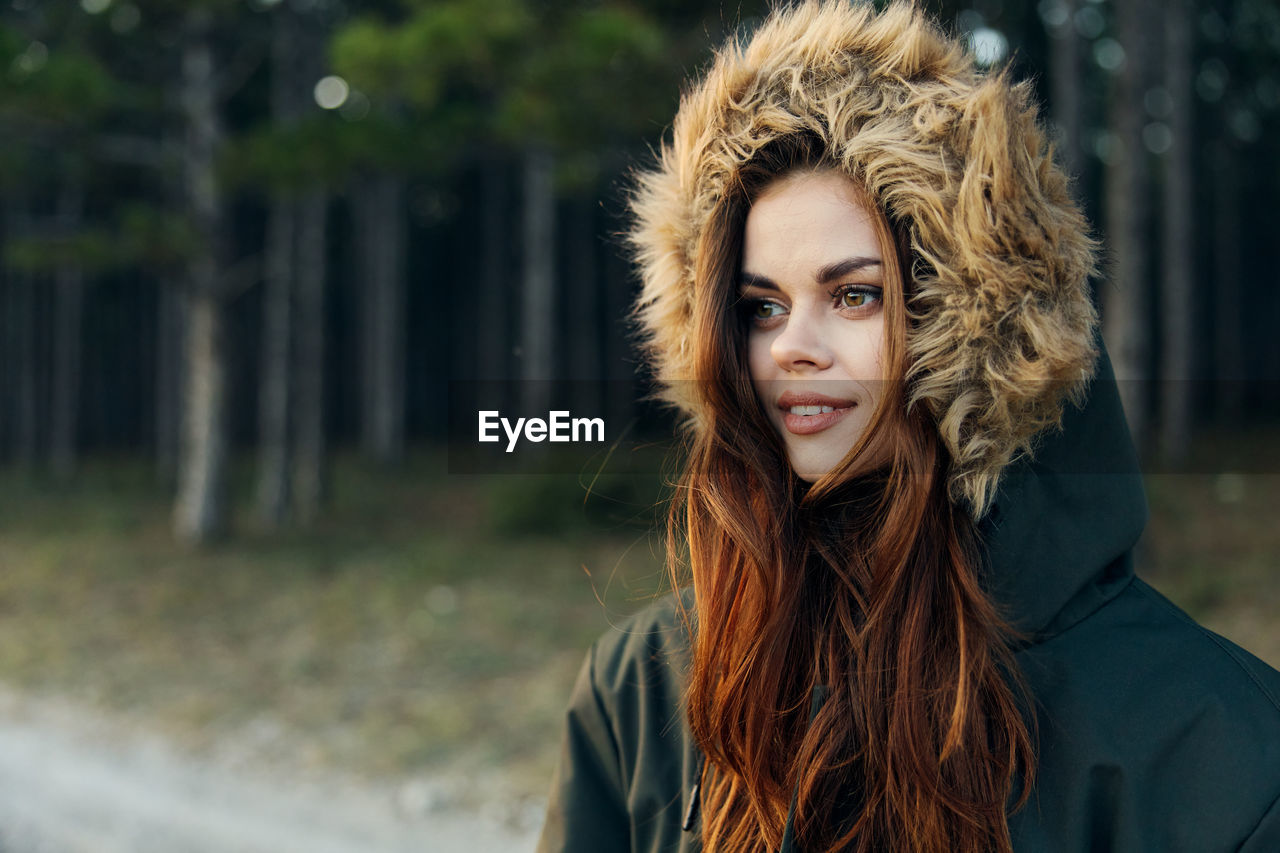 Young woman wearing fur hat while standing outdoors