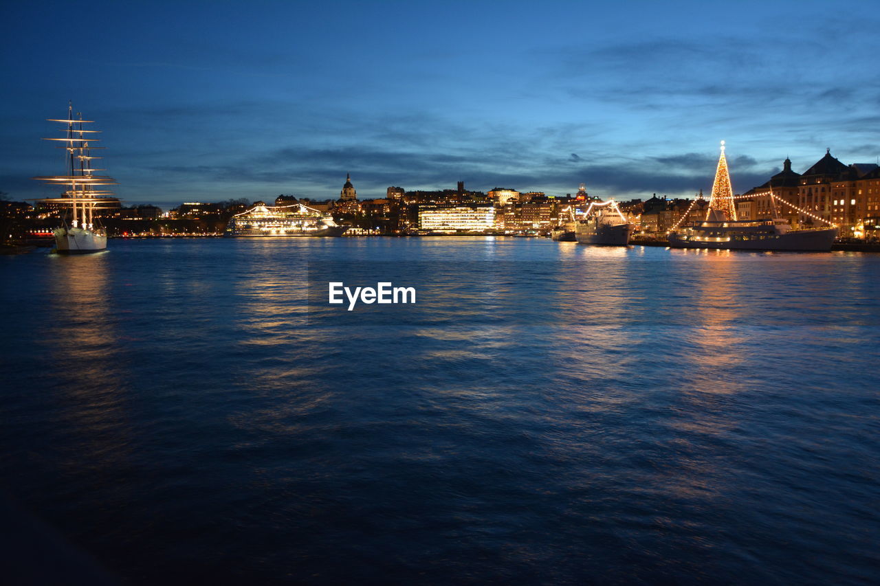 Illuminated buildings in city at waterfront