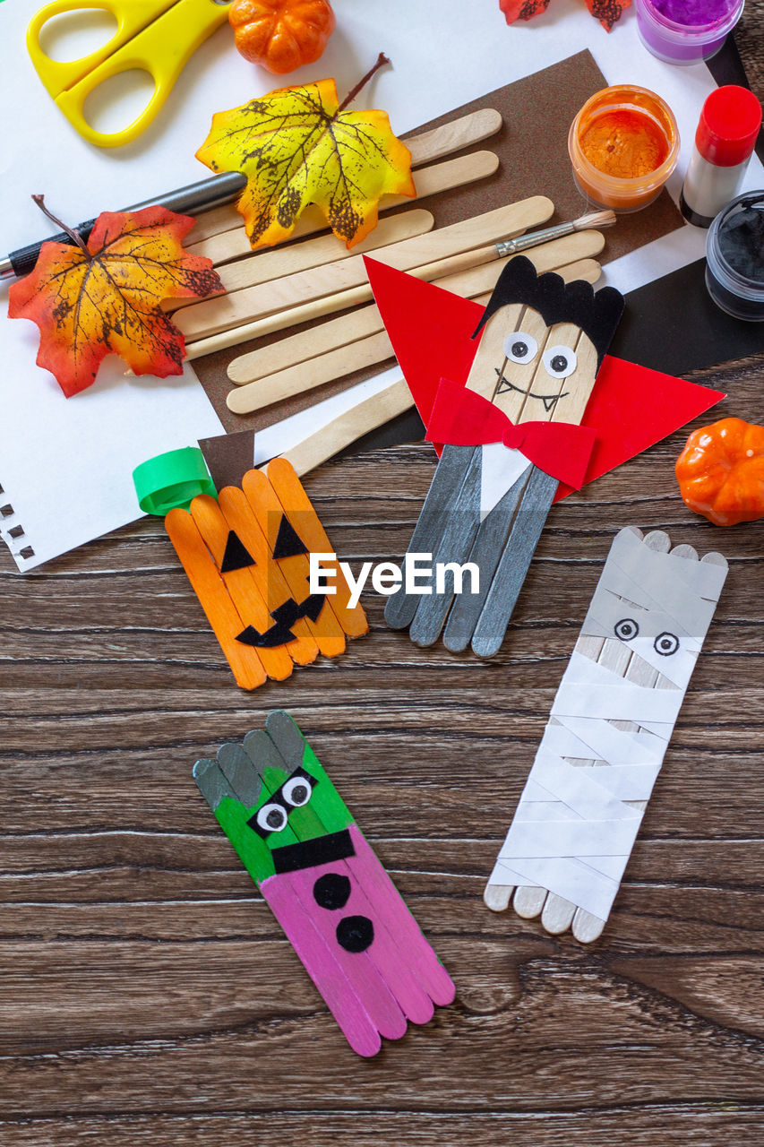 Halloween ghost, pumpkin, mummy and vampire toy gift stics puppets on wooden table. handmade. 