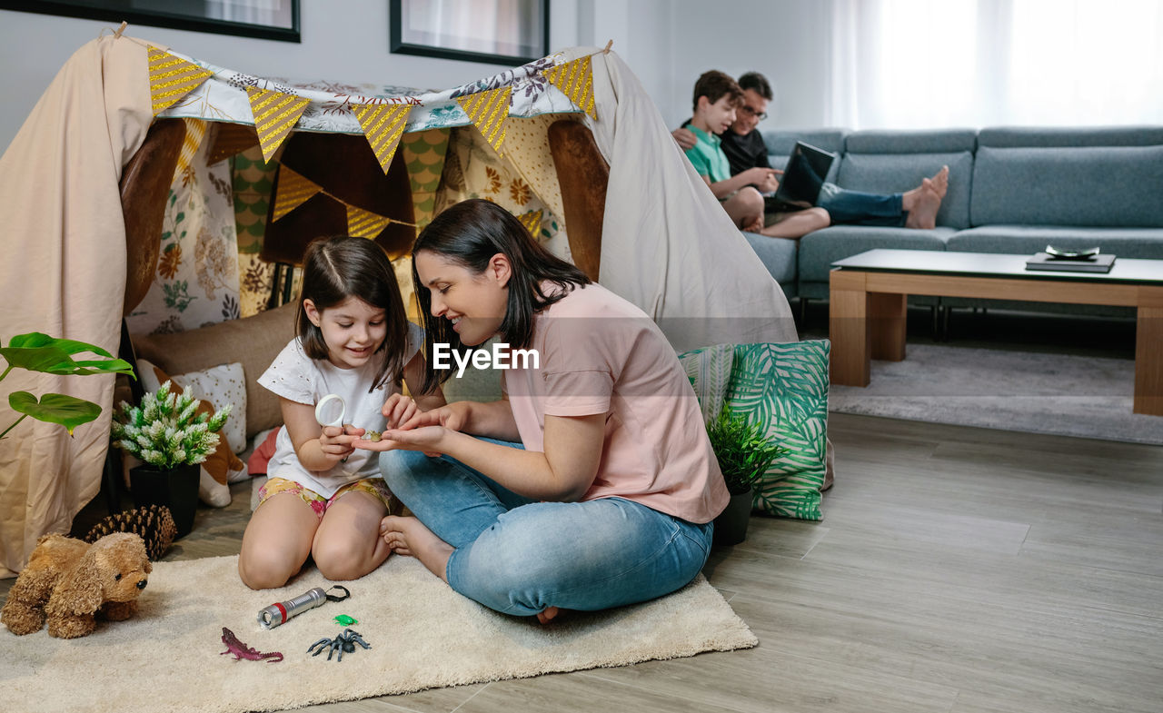 Cheerful mother and daughter playing at home