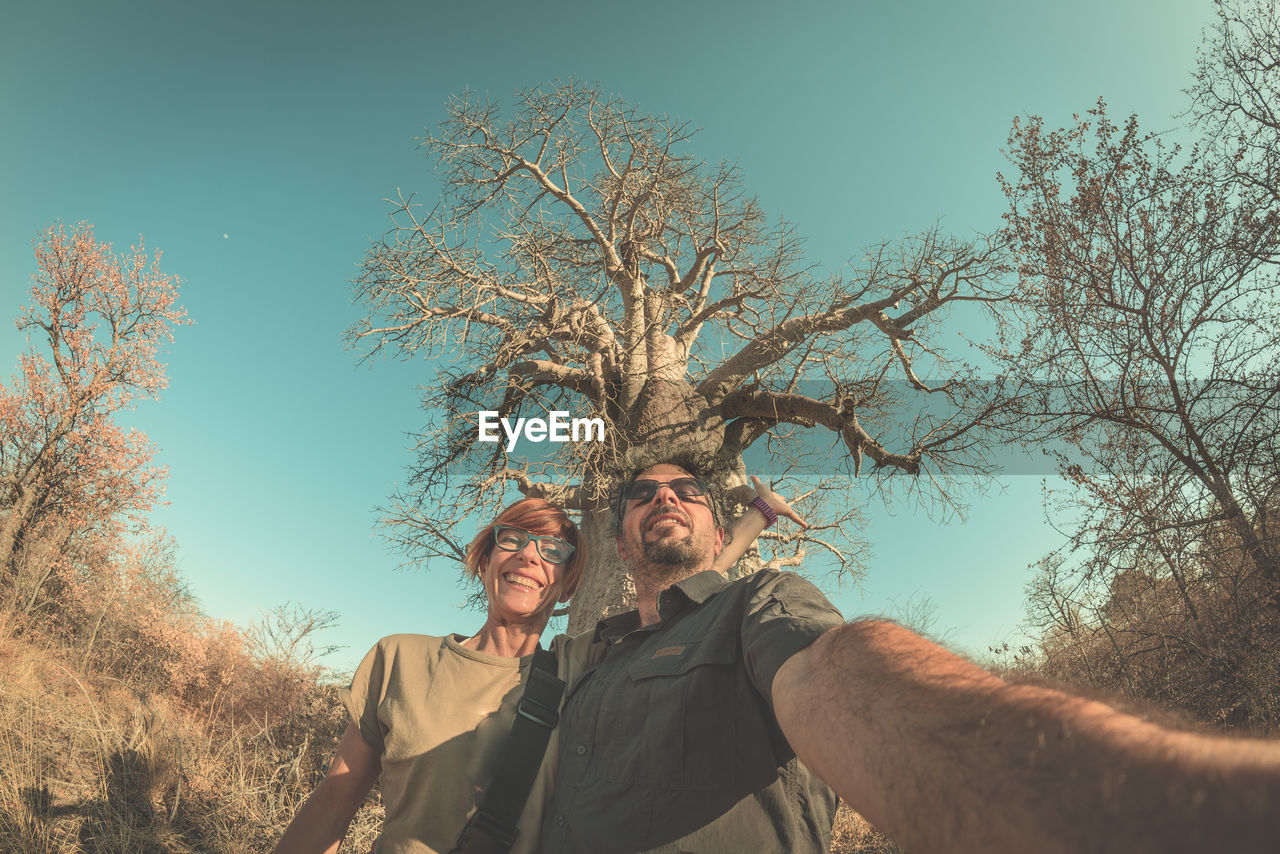 Portrait of man and woman taking selfie at savannah