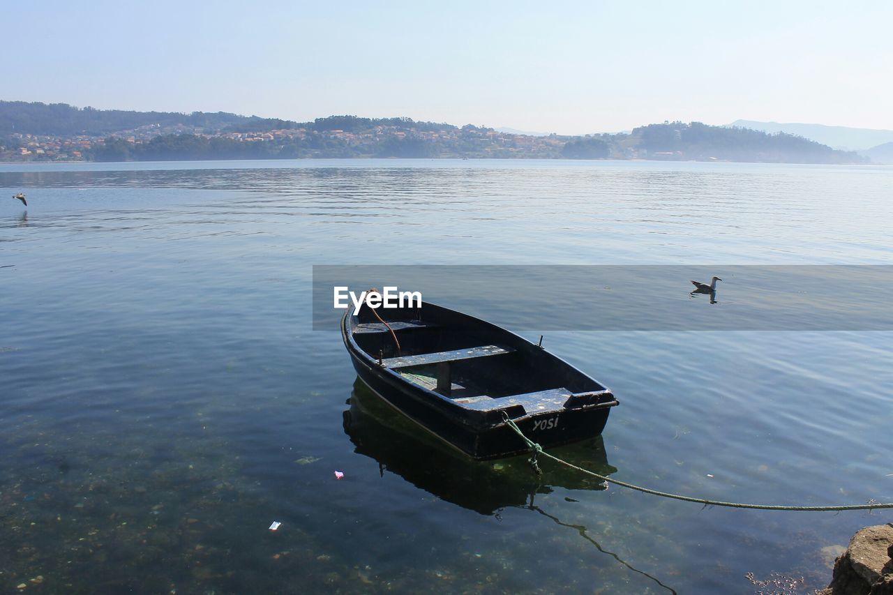 Boat moored in lake against sky