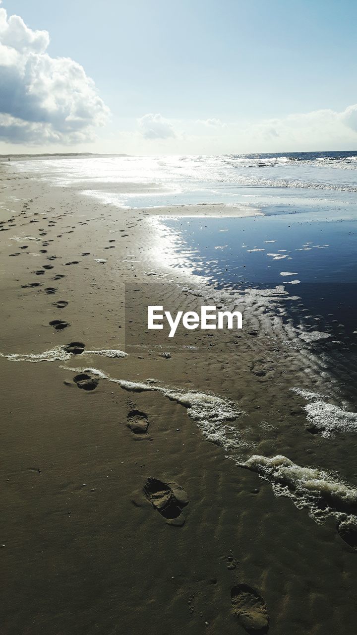 Scenic view of beach against cloudy sky