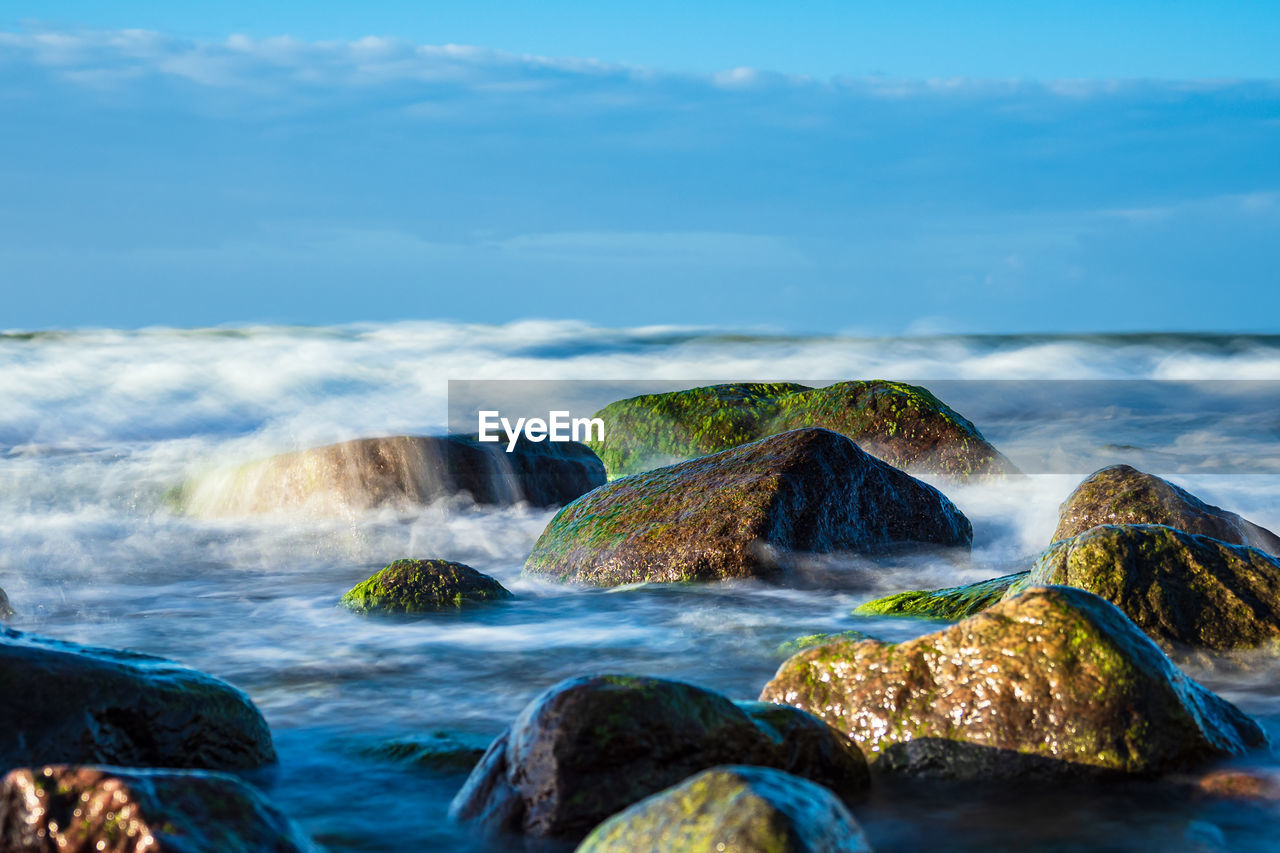 Scenic view of rocks in sea against sky