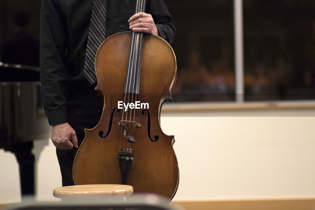 Midsection of man with cello during music concert