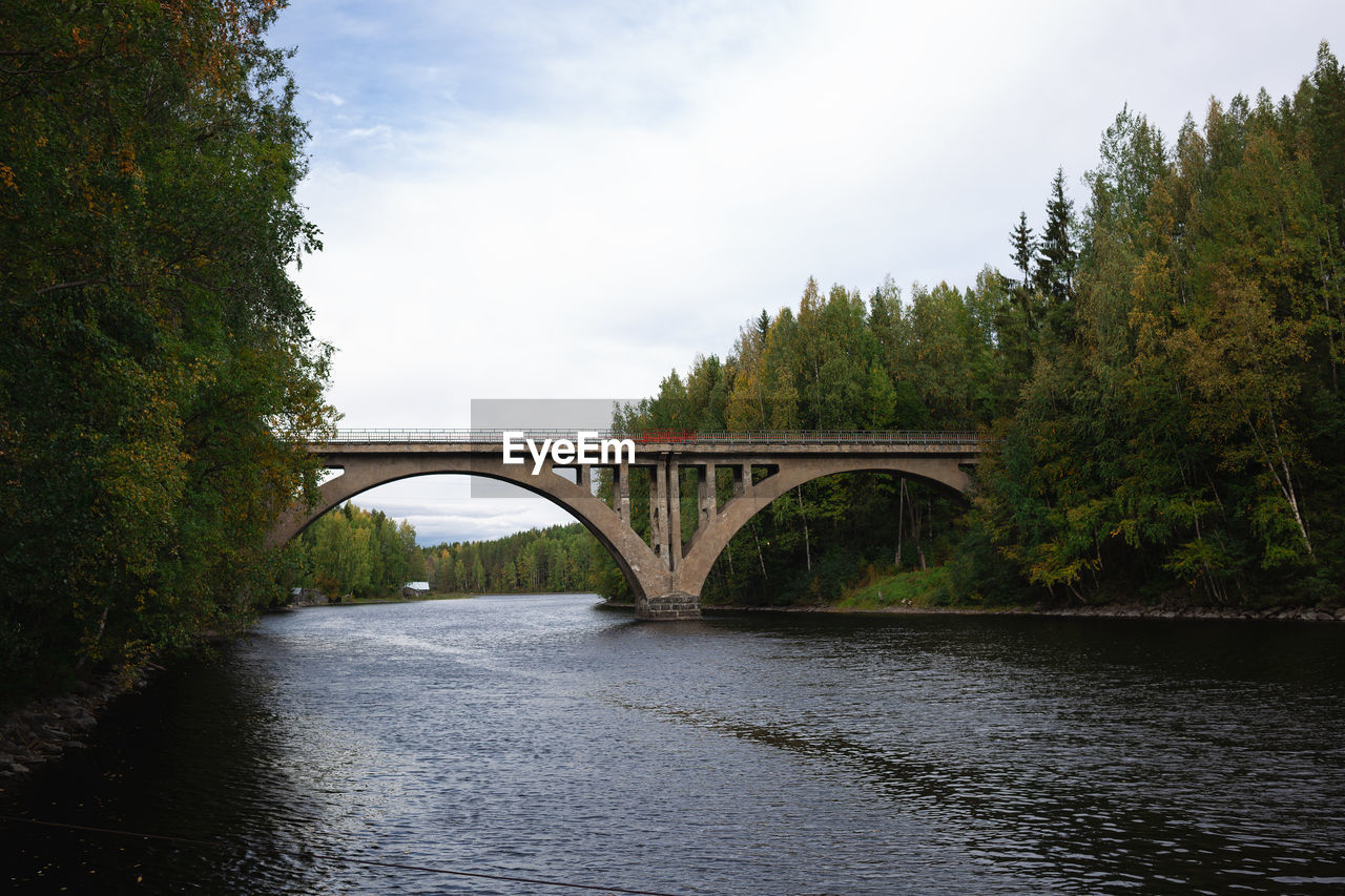 bridge, river, water, architecture, built structure, tree, reflection, transportation, nature, sky, plant, arch bridge, environment, landscape, arch, cloud, waterway, no people, travel destinations, body of water, travel, forest, city, scenics - nature, reservoir, tranquility, outdoors, beauty in nature, land, tourism, day, idyllic