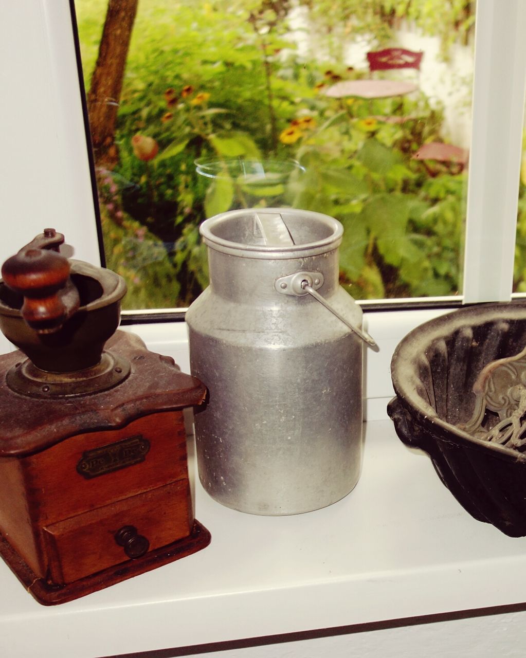 High angle view of milk canister and grinder on window sill