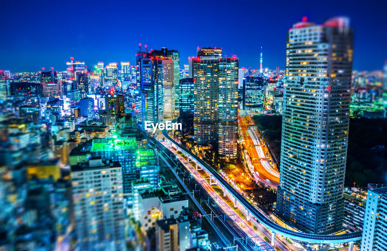 ILLUMINATED BUILDINGS IN CITY AT NIGHT