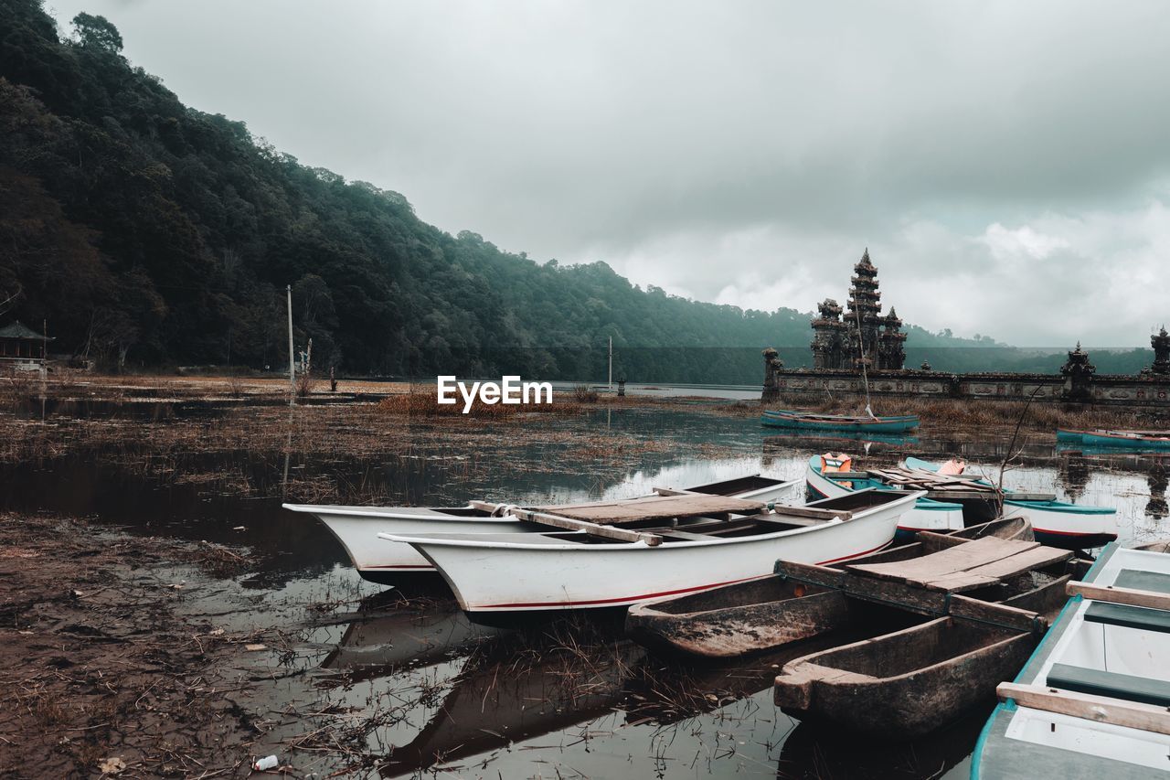 Boats moored on shore against sky