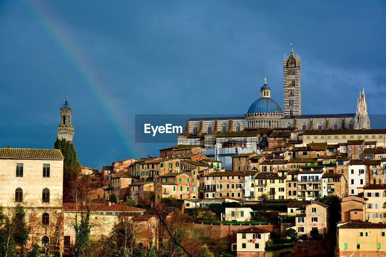 Low angle view of siena cathedral and town against blue sky