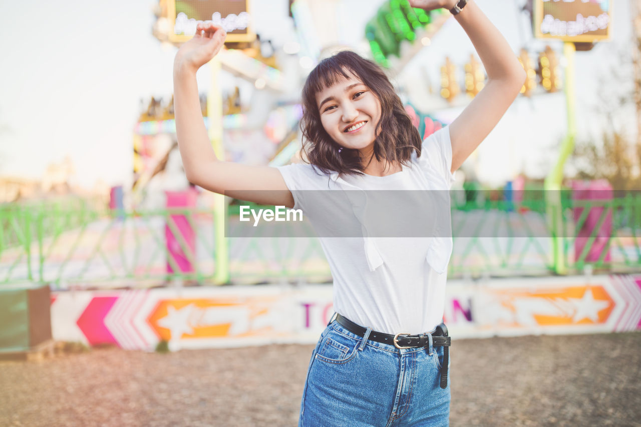 Happy beautiful asian girl in an amusement park, smiling. summer holidays and vacation 