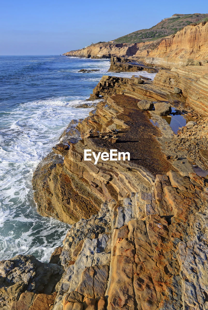 Scenic view of rocks on beach against sky