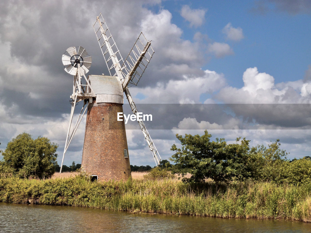 TRADITIONAL WINDMILL ON FIELD AGAINST SKY