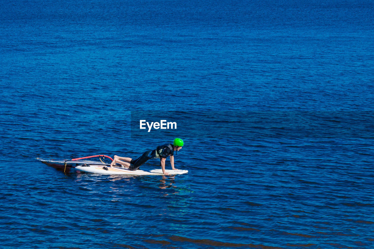 Full length of man on paddleboard motor at sea