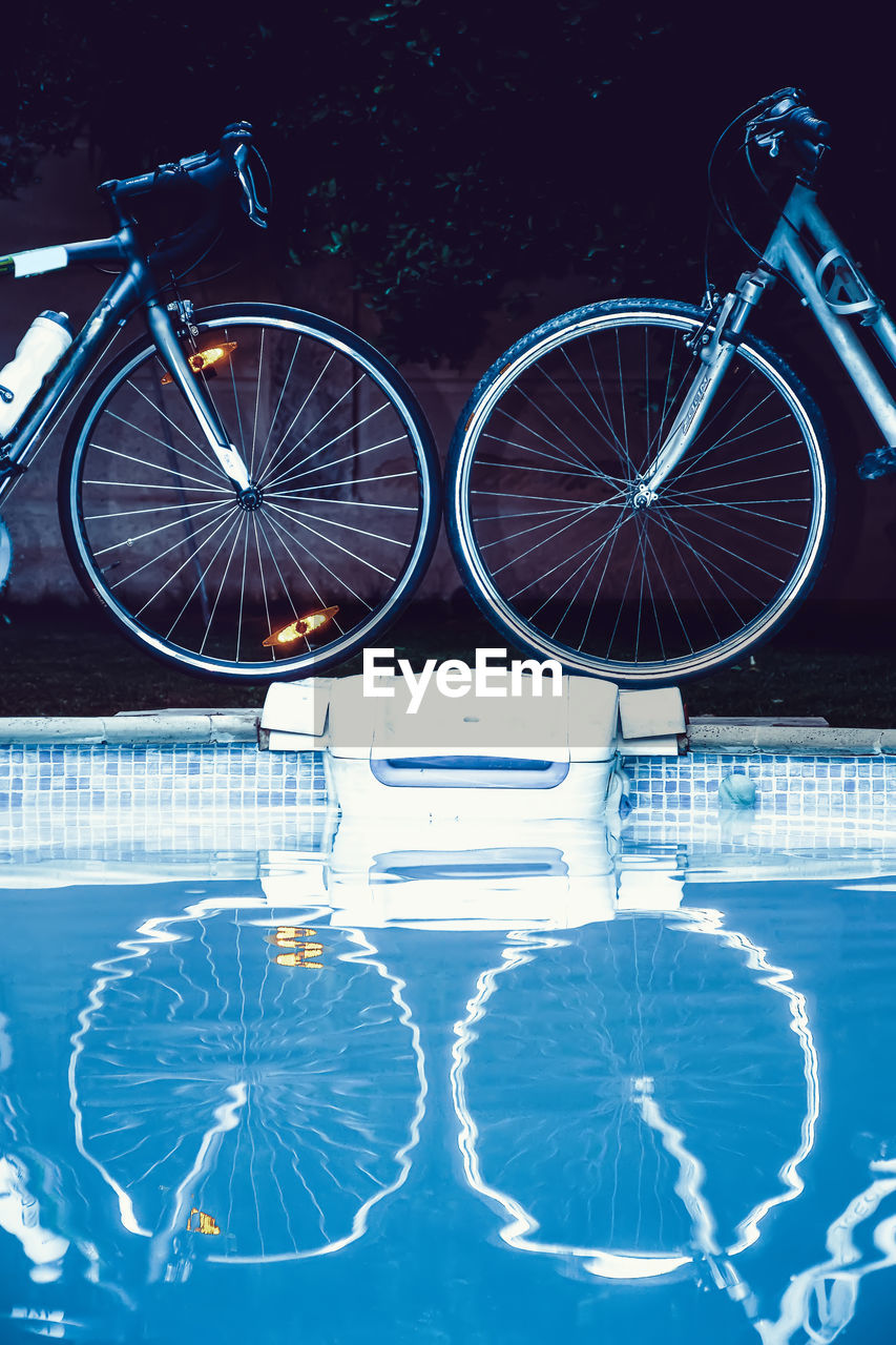 Reflection of bicycles on swimming pool