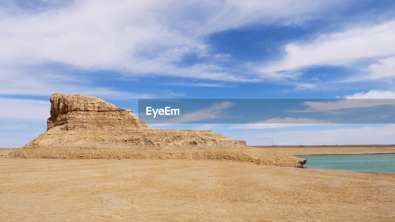 SCENIC VIEW OF SAND DUNES AGAINST SKY