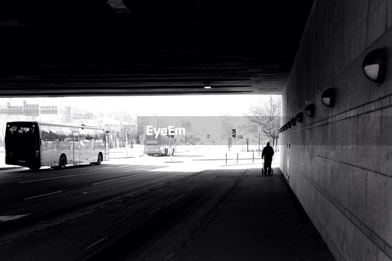 WOMAN WALKING ON ROAD IN CITY