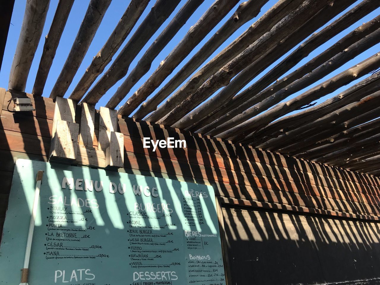 LOW ANGLE VIEW OF TEXT ON GLASS CEILING OF BUILDING