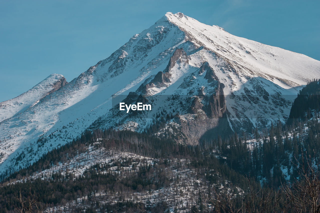 Low angle view of snowcapped mountain against sky