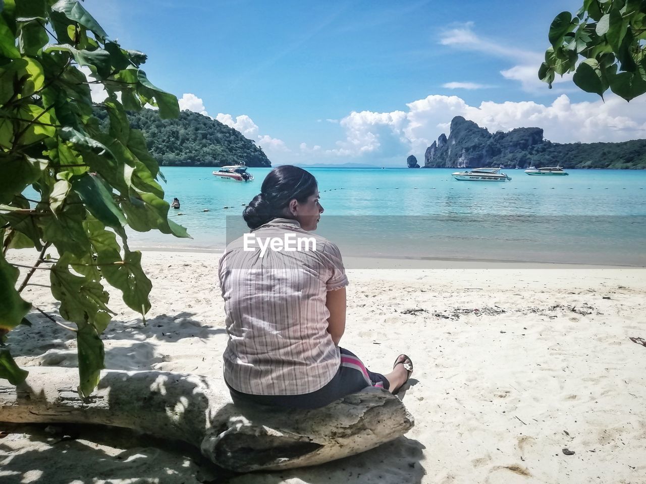 Woman sitting at sandy beach