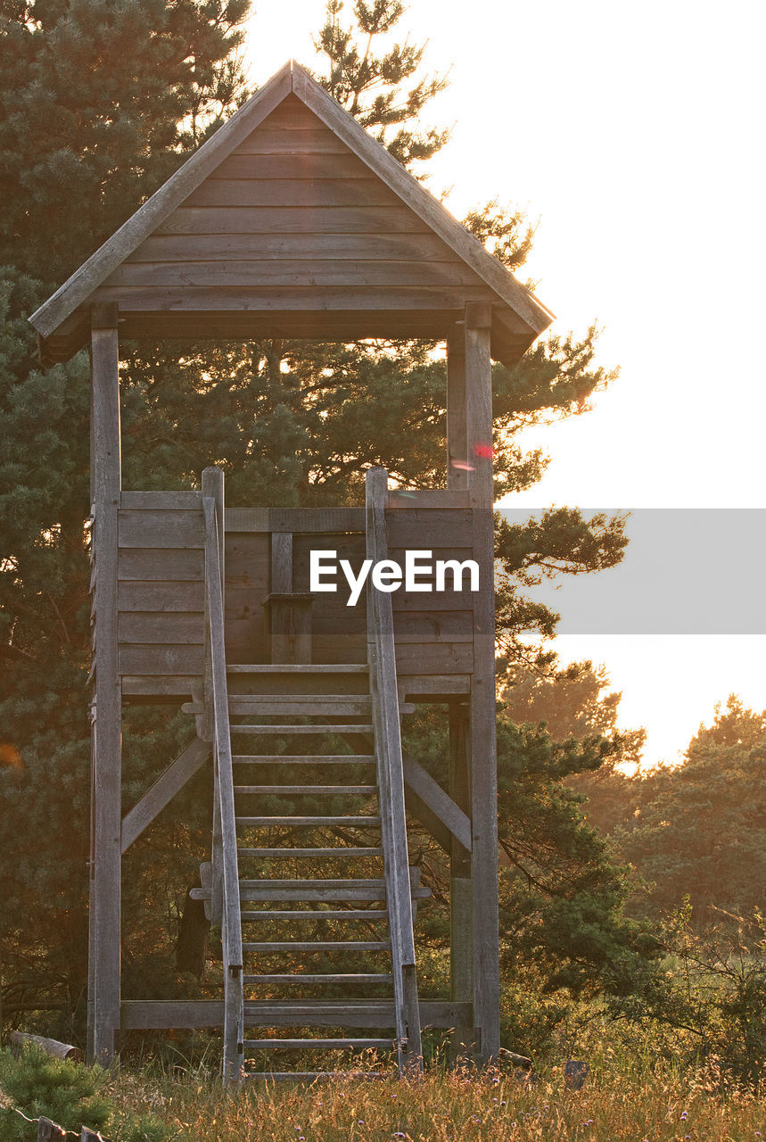 WOODEN STRUCTURE ON FIELD AGAINST SKY