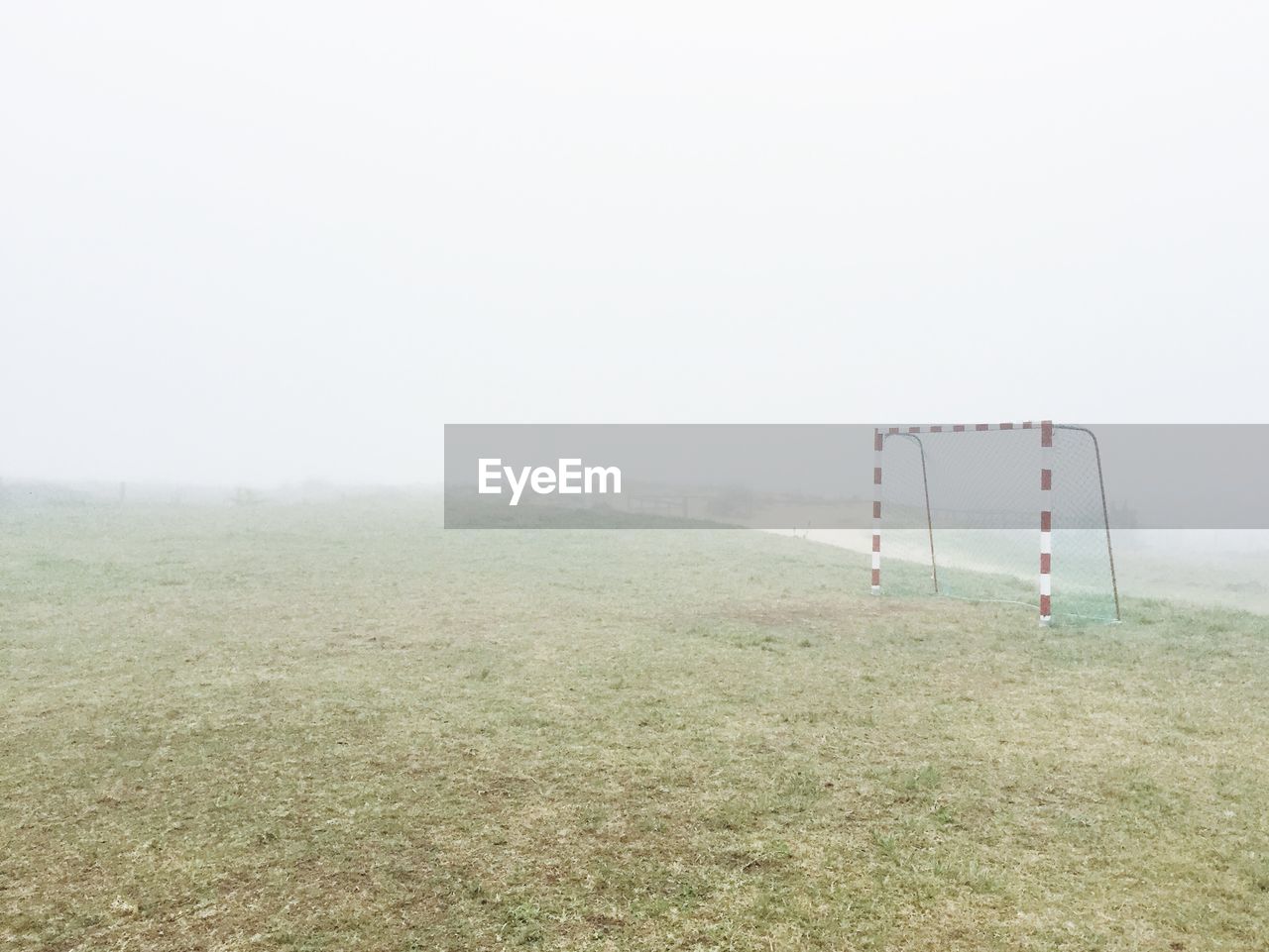 Soccer goal on playing field against clear sky