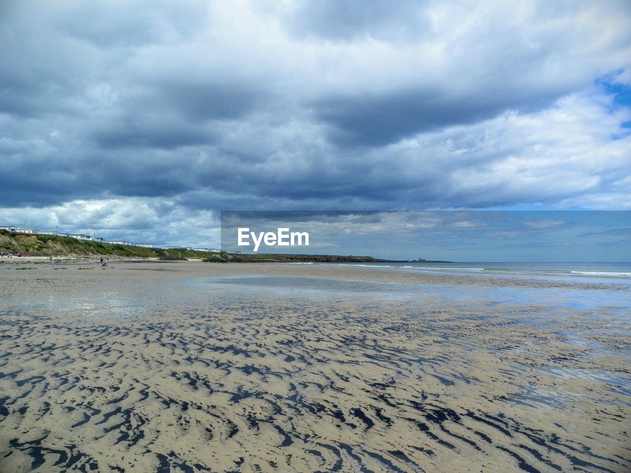 VIEW OF BEACH AGAINST CLOUDY SKY