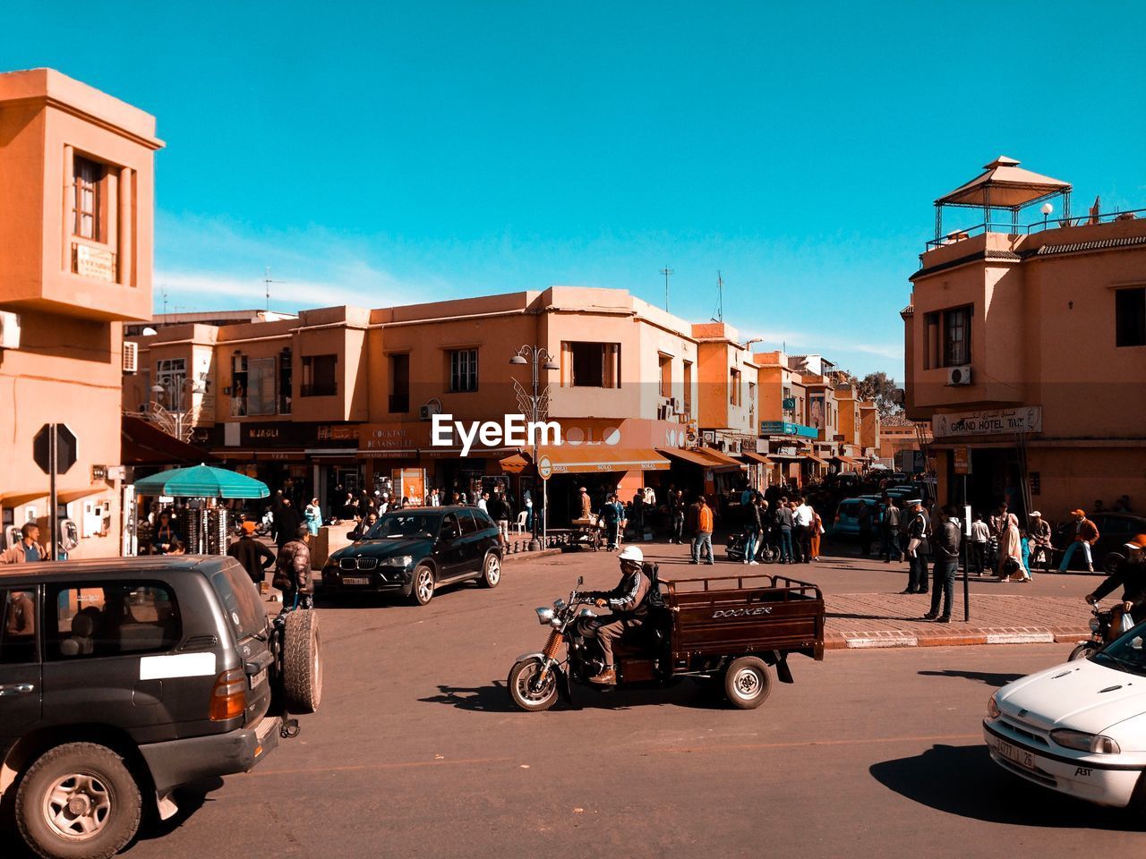 CARS ON ROAD BY BUILDINGS IN CITY