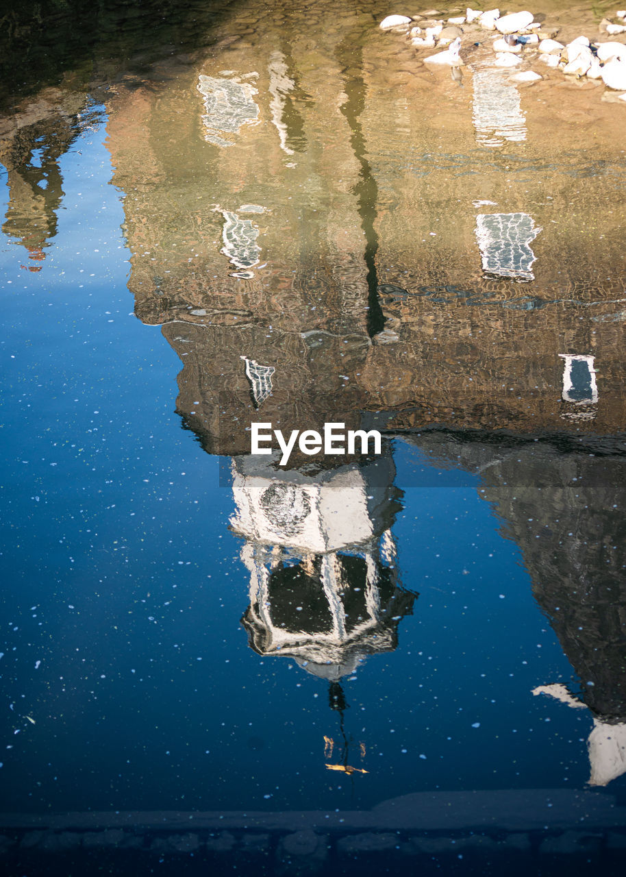 REFLECTION OF BUILDING IN PUDDLE ON SEA