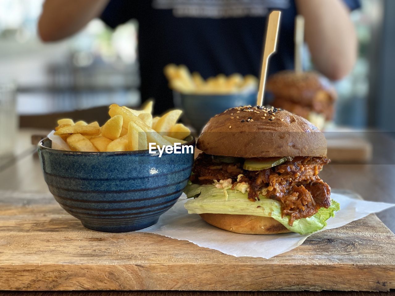 CLOSE-UP OF HAND HOLDING BURGER