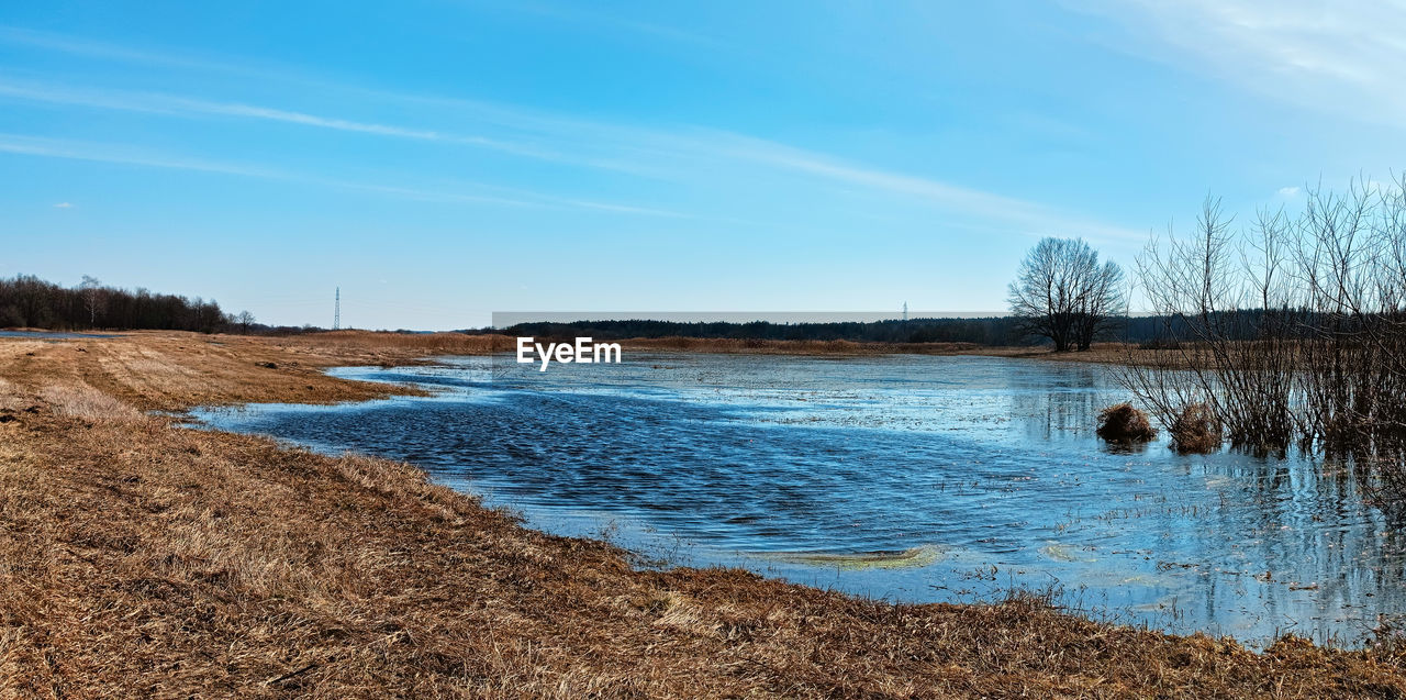 sky, water, shore, nature, river, scenics - nature, landscape, reflection, body of water, land, reservoir, tranquility, beauty in nature, plant, tranquil scene, tree, environment, no people, blue, cloud, morning, day, non-urban scene, wetland, wilderness, natural environment, beach, coast, winter, marsh, rural area, outdoors, horizon, travel destinations