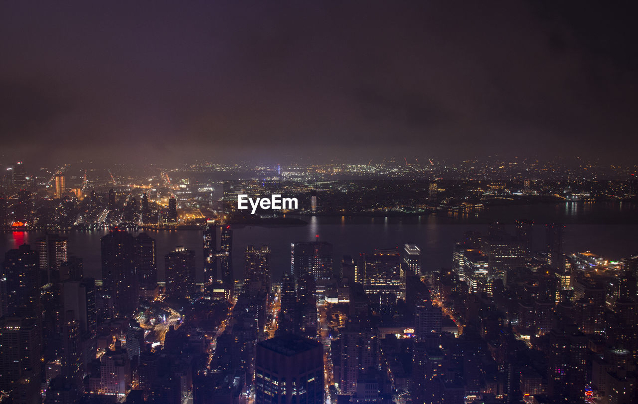 High angle view of illuminated cityscape against sky at night