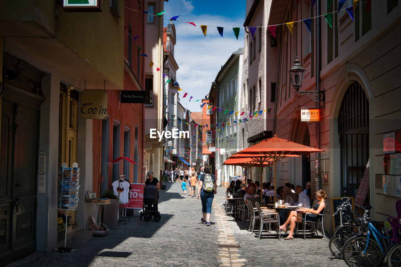 PEOPLE ON STREET AMIDST BUILDINGS