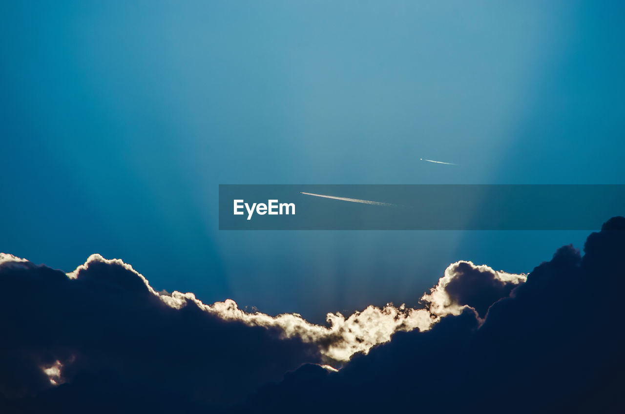 LOW ANGLE VIEW OF VAPOR TRAIL IN BLUE SKY