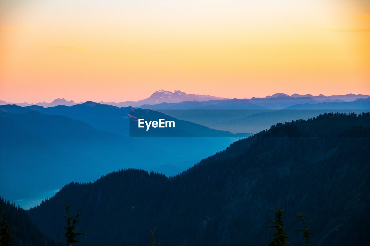 SCENIC VIEW OF MOUNTAINS AGAINST SKY AT SUNSET