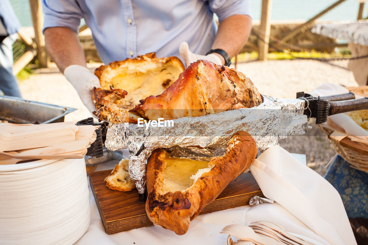 Midsection of man holding roasted pork